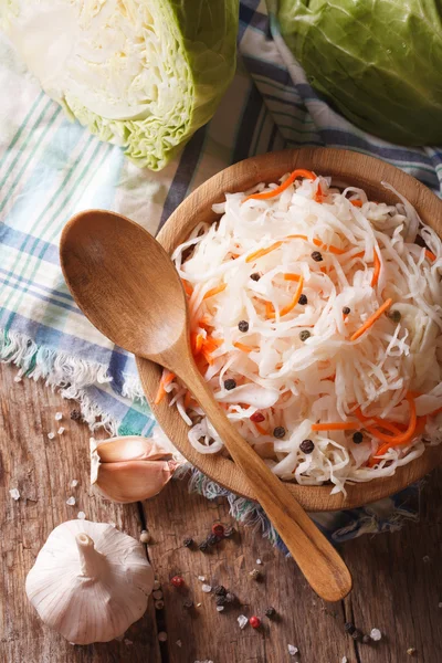 Sauerkraut and carrots in a wooden plate close up vertical top v — Stock Photo, Image