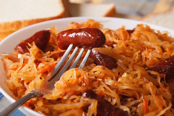 Sauerkraut mit Wurst auf weißem Teller. horizontal — Stockfoto