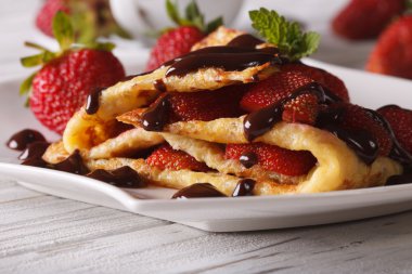 Beautiful crepes with fresh strawberries close-up clipart