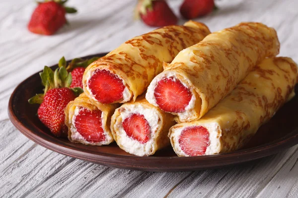 Crepes com morangos frescos e queijo de creme em um prato — Fotografia de Stock