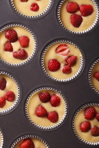 Raw strawberry muffins in baking dish vertical top view — Stock Photo, Image