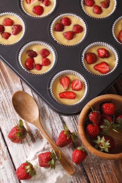 Preparation of muffins with fresh strawberries vertical top view — Stock Photo, Image