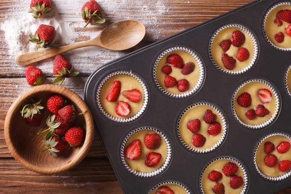 Matlagning muffins med färska jordgubbar horisontella ovanifrån — Stockfoto
