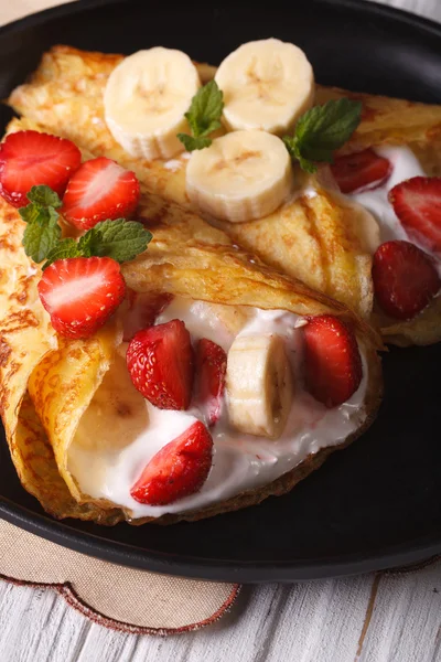 Crepes with strawberries, bananas and cream close-up.  Vertical — Stock Photo, Image