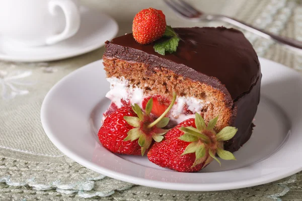 Кусочек шоколадного торта с клубникой на тарелке крупным планом — стоковое фото