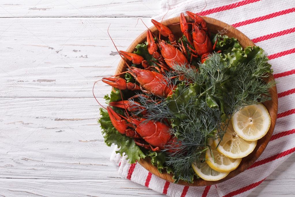 crayfish with herbs and lemon on a plate. Horizontal top view 