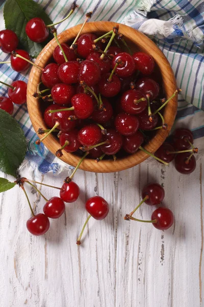 Cerises rouges dans un bol en bois vue verticale ci-dessus, rustique — Photo