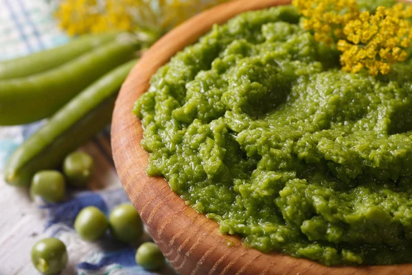 Puree of fresh green peas macro in a wooden bowl. horizontal — Stock Photo, Image