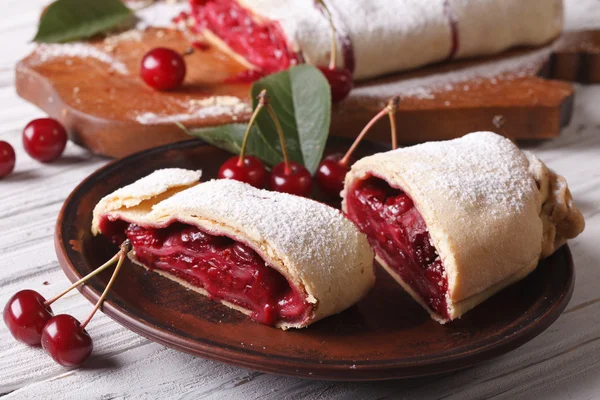 Trozos de strudel con cereza de cerca en un plato. horizontal — Foto de Stock