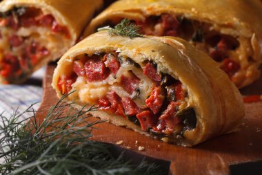 homemade strudel with ham, cheese and fresh vegetables macro clipart