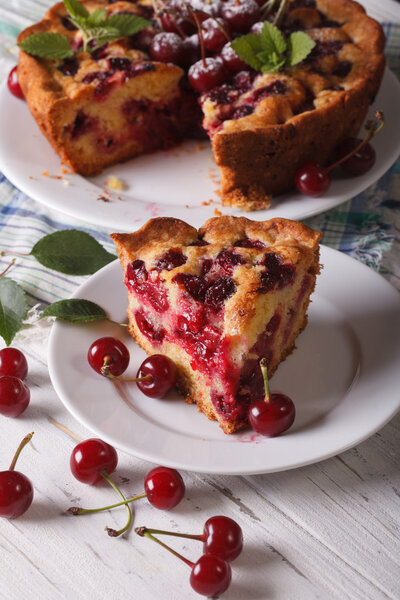 Нарезанный домашний вишневый торт крупным планом по вертикали
