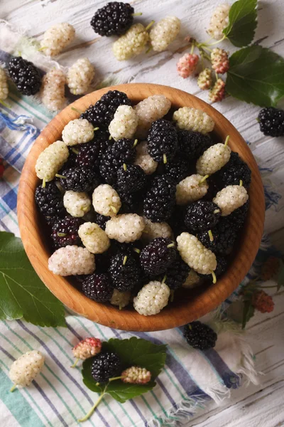 White and black mulberries in bowl close-up. vertical top view — Stock Photo, Image