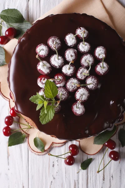 Cherry cake with chocolate on a table close-up. vertical top vie — 图库照片