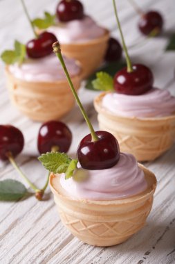 Mini cakes with pink cream and fresh cherries