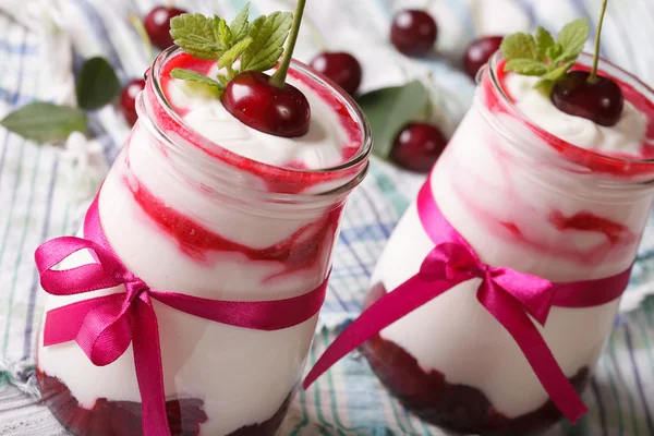 Yogur con cerezas en un frasco de vidrio de cerca. horizontal — Foto de Stock