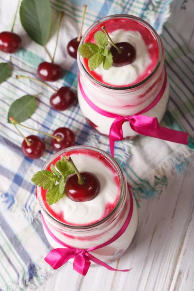 Yogurt with cherries close up. vertical top view — Stock Fotó