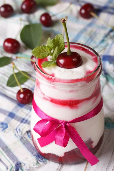 Whipped cream with a cherry in a glass jar vertical — 스톡 사진