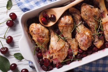 chicken leg with cherry in dish for baking. Horizontal top view