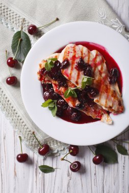 Grilled chicken with cherry sauce close up. vertical top view