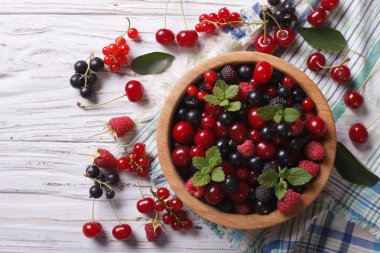 Berry mix in a wooden bowl horizontal top view