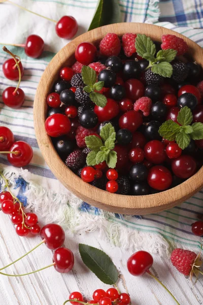 Berry mix in a wooden bowl close-up. Vertical — Stock Photo, Image