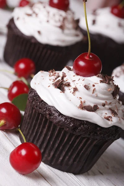 Deliciosos cupcakes de chocolate com cereja de perto, vertical — Fotografia de Stock