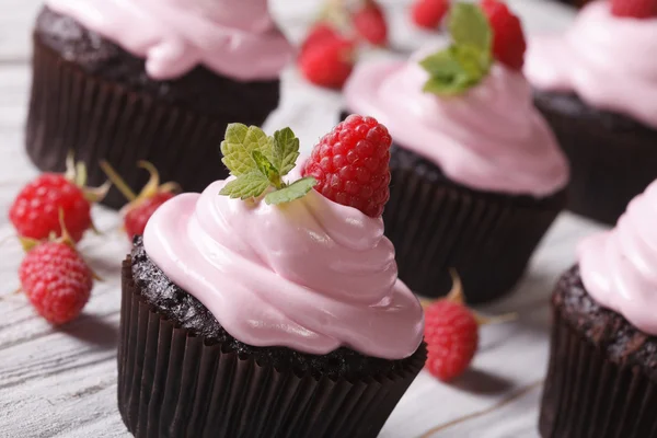 Cupcakes de chocolate con crema rosa y primer plano de frambuesa . —  Fotos de Stock