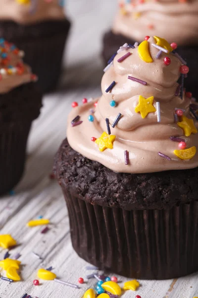 Chocolate cupcakes with light brown cream macro. vertical — Stock Photo, Image