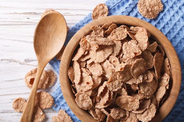 Cereal flakes in a wooden bowl closeup. Horizontal top view — Stock Photo, Image