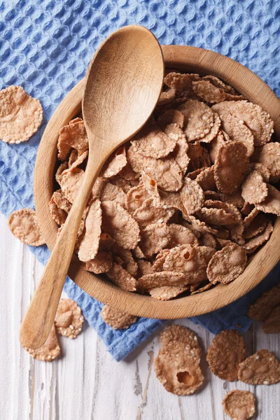 Cereal flakes in a wooden bowl closeup. vertical top view — Stock Photo, Image