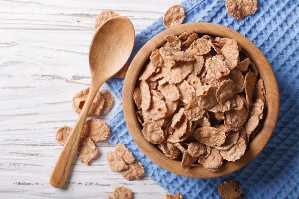 Cereal flakes in a wooden bowl. Horizontal top view — Stock Photo, Image