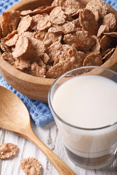 Healthy bran flakes in a wooden bowl and milk close-up. Vertical — Stock Photo, Image