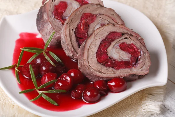 Meat roll filled with cherries and sauce close-up. Horizontal — Stock Photo, Image