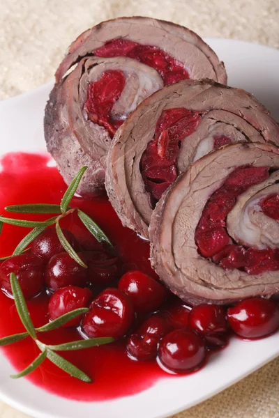 Meat roll with cherries and sauce close-up. Vertical — Stock Photo, Image