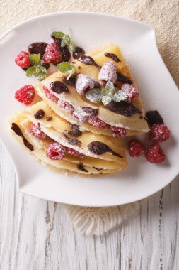 raspberry crepes with chocolate and mint closeup. vertical top v