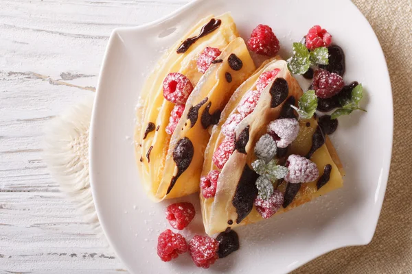 Raspberry crepes with chocolate and mint closeup. horizontal top — Stock Photo, Image