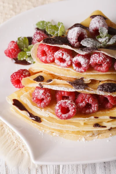 Beautiful crepes with raspberries and chocolate close-up. vertic — Stock Photo, Image