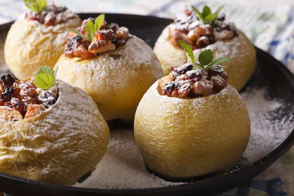 Запеченные яблоки с изюмом и грецкими орехами на тарелке крупным планом — стоковое фото