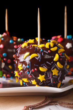 Delicious apples in chocolate with candy sprinkles vertical