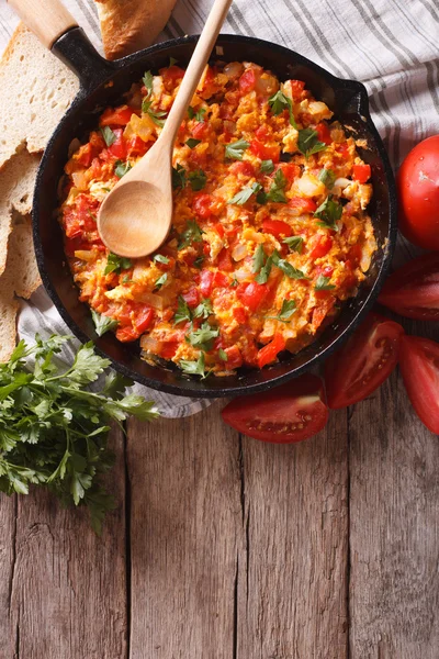 Menemén en una sartén y los ingredientes sobre la mesa. vista superior vertical — Foto de Stock