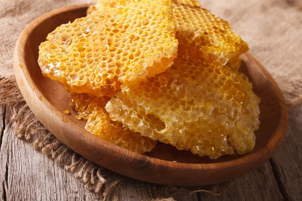 Свежий мед расчески на деревянной тарелке крупным планом. hhhontal — стоковое фото