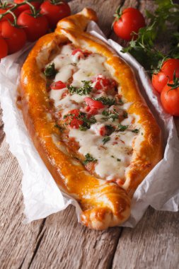 Hot Turkish Pizza and ingredients close-up on a table. vertical