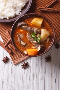 Thai beef massaman curry and rice side dish. vertical top view