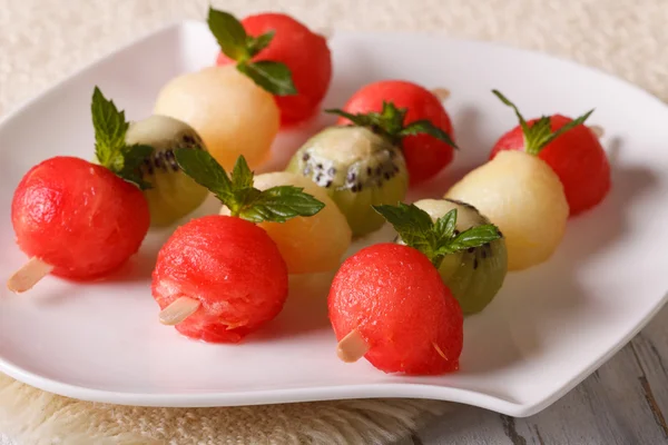 Delicious balls of watermelon, kiwi and melon on skewers close-u — Stock Photo, Image