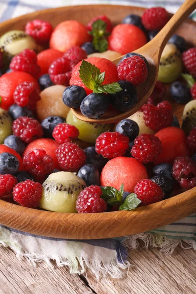 Summer fruit salad in wooden bowl closeup. vertical — Stock Photo, Image