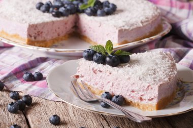 Cutting slice of delicious blueberry cheesecake close-up. horizo