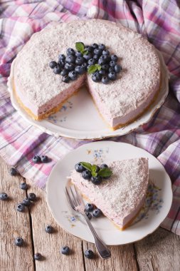 Cut a piece of blueberry cheesecake close-up on a plate. Vertica