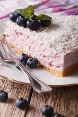 piece of blueberry cheesecake with fresh berries closeup vertica