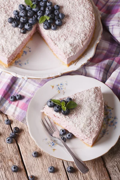 Sliced blueberry cheesecake with coconut closeup. vertical top v