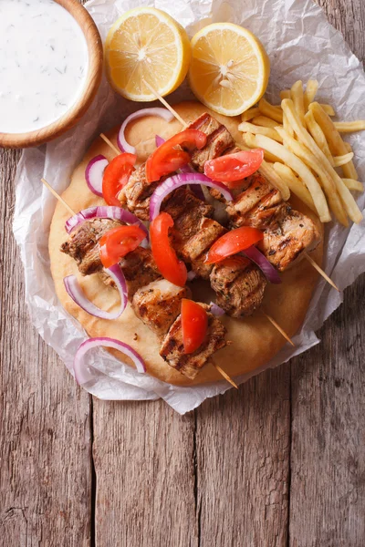 Greek souvlaki with vegetables and french fries. vertical top vi